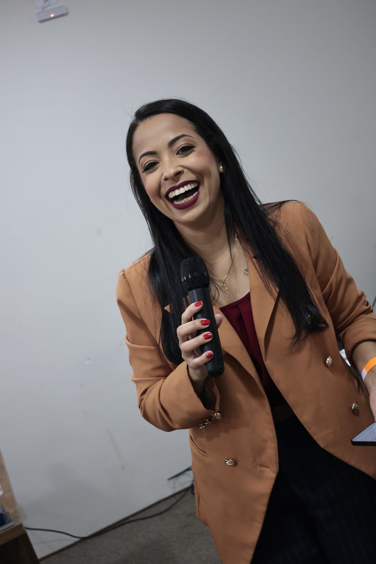 Anfitriã rindo com microfone na mão